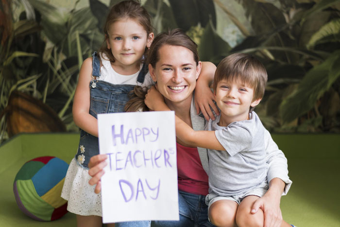 full-shot-kids-hugging-happy-teacher