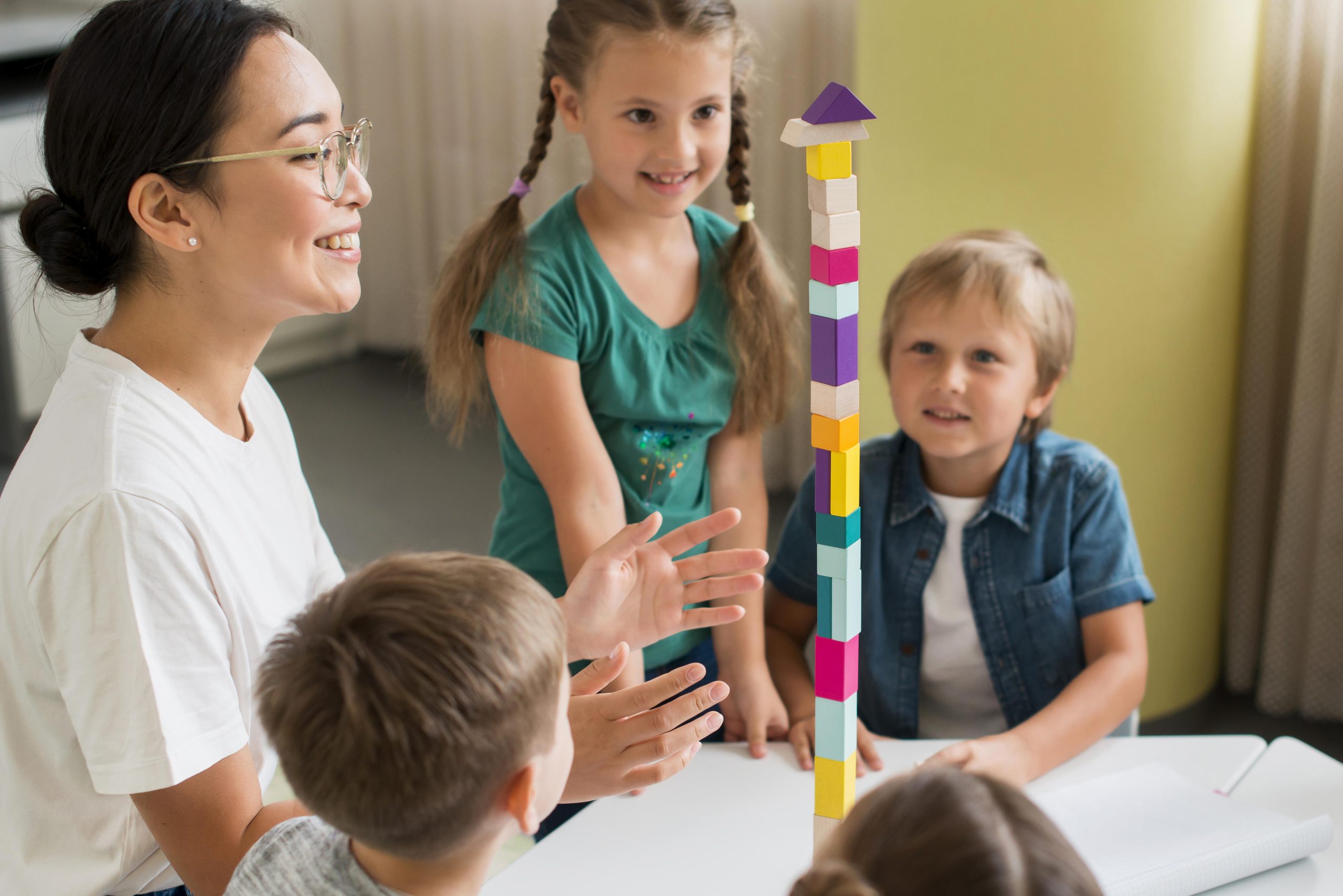 woman-teaching-kids-how-play-with-colorful-tower